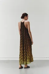 Vestido largo con cuello halter y corte fluido, con estampado animal print en tonos marrones y amarillos. Confeccionado en satén de viscosa.