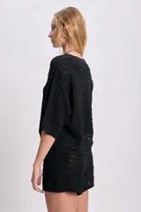 Top de punto crochet color negro con mangas cortas y cuello redondo.
