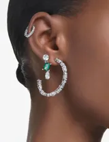 Par de aros colgantes con baño de rodio, adornados con circonitas Swarovski. Cuentan con una circonita redonda blanca en la parte superior, una circonita rectangular verde en el centro y una circonita blanca en forma de lágrima en la parte inferior.