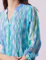 Blusa de gasa estampada, marca Ruby Rd. Cuello a la base, escote en V y abertura central con botones. Delantera con plisados. Largo de manga regulable con presilla y botón.