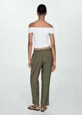 Pantalón fluido color verde militar, de corte recto, con cintura elástica ajustable con cordón y bolsillos laterales.