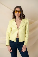 Chaqueta de cuero ecológico color vainilla, con cuello clásico, cierre frontal descentrado con cremallera metálica dorada y pespuntes decorativos.