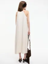 Vestido largo color crudo, de corte recto y breteles finos.