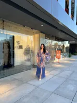 Vestido largo de manga ancha y escote en V, con cinturón a juego, confeccionado en tela estampada con motivos cachemir en tonos azules, rojos y ocres.