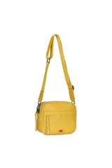 Bandolera amarilla de cuero sintético con correa larga regulable y desmontable. Posee un bolsillo frontal con cierre y un aplique de labios rojos en la esquina inferior.