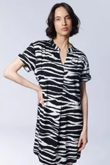 Vestido camisero corto con estampado de cebra en blanco y negro, cuello mao y mangas cortas.
