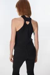 Top halter marrón oscuro, estilo chaleco, confeccionado con parches de cuero cosidos en patrón de rombos con costura de ganchillo visible. El cuello es de punto trenzado.