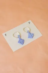 Aros colgantes con argolla dorada y dije de vidrio transparente con forma irregular.
