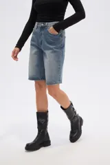 Bermuda de jean azul claro, estilo boyfriend, tiro alto, con largo a la rodilla y roturas.