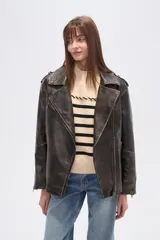 Chaqueta estilo biker de eco-cuero con efecto desgastado, color negro. Presenta cuello solapa, cierre asimétrico frontal, bolsillos con cierre y hombreras.