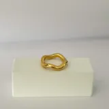 Anillo dorado de acero quirúrgico hipoalergénico con baño en oro 18K, de forma irregular.