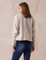 Campera de lino color beige, marca Dash, con abertura central y botones. Tiene bolsillos aplicados en la parte delantera.