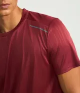 Remera deportiva gris con cuello redondo, mangas cortas, estampa heat print y detalle en los hombros. Confeccionada en tejido de malla con tecnología Dry.
