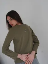 Remera color beige de manga larga con cuello redondo.