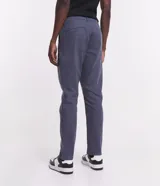 Pantalón de vestir marrón, de corte skinny, con bolsillos laterales y traseros. Se ajusta a la cintura con cinturón de cuero marrón.