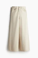 Pantalón de jean color crema, de corte amplio y cintura alta, con detalle de trenzado en la pretina.