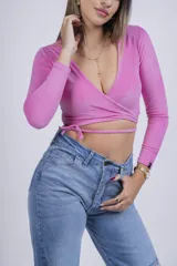 Remera corta gris de punto con escote cruzado y mangas largas.