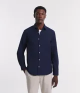 Camisa de hombre color celeste, de corte regular, con cuello inglés, manga larga y abotonado frontal.