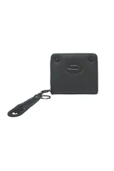 Billetera tipo monedero cuadrada de material sintético negro texturizado, con un relieve de labios en el centro. Incluye un llavero desmontable de goma con texto troquelado.