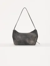 Cartera tipo bandolera color gris oscuro, realizada en cuero ovino, con cierre metálico y forro de poliéster jacquard. Tiene doble bolsillo frontal con cierre imantado y apliques metálicos níquel. Incluye correa corta de cuero para usar al hombro.