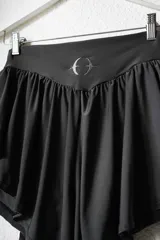 Short deportivo gris con cintura elástica y detalle de volados laterales.