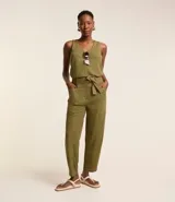 Musculosa verde oliva de piquet con escote en pico, breteles anchos, pequeñas aberturas laterales y bajos con pespuntes.