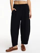 Pantalón negro tipo chino con bolsillos laterales y pretina elástica.