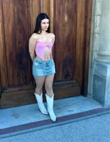 Top bandeau rosado con detalle de abertura en el centro y accesorio dorado.