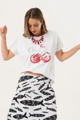 Remera blanca de manga corta con estampado de cerezas y la palabra "Cherry" en cursiva.