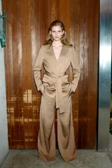 Pantalón palazzo color beige de tiro alto, con bolsillos delanteros y pernera ancha.