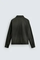 Sobrecamisa de denim de algodón negro con efecto lavado, corte relajado (relaxed fit). Presenta cuello solapa, cierre frontal con cremallera, manga larga con puño abotonado y bolsillo plastrón en el pecho.