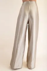 Pantalón de vestir color champagne, de tejido satinado, con cintura alta plisada y pierna ancha.
