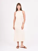 Vestido midi color crudo, de corte recto y cuello halter.