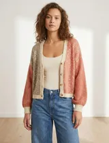 Cardigan de punto con escote en V y abotonadura frontal. Presenta un diseño colorblock con paneles en beige claro, rosa salmón y beige con lentejuelas dispersas. Las mangas son largas y abullonadas con puños y ruedo en punto acanalado beige claro.