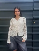 Saco de broderie color crudo con cuello en V y botones de corcho. Largo hasta la cadera.