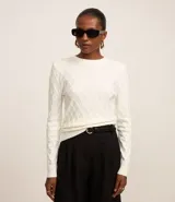 Blusa de tricot color blanco con textura en relieve y hombreras.