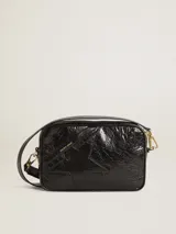 Bolso bandolera negro de cuero con efecto desgastado y estrella en relieve. Tiene correa de cuero ajustable y detalles metálicos dorados.