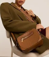 Bolso bandolera pequeño color marrón con textura geométrica en relieve. Tiene correa larga regulable, cierre de cremallera y separadores internos.