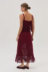 Falda midi tejida color bordó, con flecos y calados en el bajo.