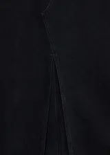 Falda midi de jean negro con abertura frontal, cierre de cremallera y botón, trabillas y cinco bolsillos.