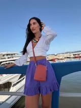 Bandolera pequeña y compacta color amarillo mostaza, realizada en símil cuero. Posee un bolsillo frontal con tapa y broche metálico, y un compartimento principal con cierre superior. Incluye correa ajustable del mismo material.