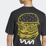 Remera negra de algodón con cuello redondo y corte holgado. Estampado frontal pequeño con un vaso de papas fritas y el logo de Adidas.