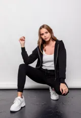 Babucha deportiva negra con puños, bolsillos frontales y cordón en la pretina.