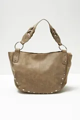 Cartera tipo hobo color beige con tachas plateadas en el borde inferior y asa de hombro trenzada.