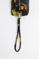 Neceser Bimba y Lola de nylon negro con estampado de cactus y flores naranjas. Tiene asa extraíble, piezas de piel, logo metálico, bolsillo interior y cierre con cremallera dorada.