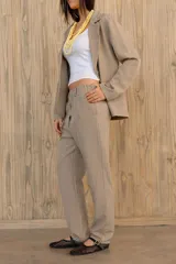 Pantalón verde con finas rayas verticales blancas, corte recto, tiro alto y bolsillos laterales.