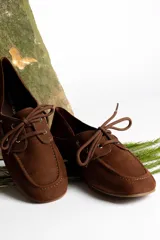 Mocasines color marrón claro con cordones y detalle de costuras en la puntera.