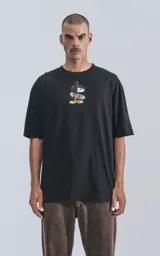 Remera negra de manga corta con cuello redondo y calce oversize. Estampado frontal de Mickey Mouse andando en skate.
