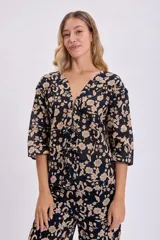 Kimono corto negro con estampado floral en tonos beige, con mangas 3/4 y lazo de ajuste en la cintura.