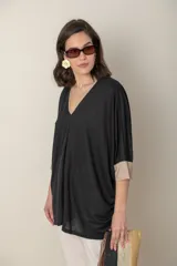 Blusa italiana color crema, tipo poncho, con escote en V con lurex, mangas 3/4 y puños ajustados.